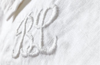 Une couturière brode du textile